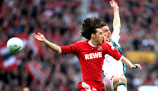 Kölns Pedro Geromel (l.) und Gladbachs Rob Friend springen am Ball vorbei