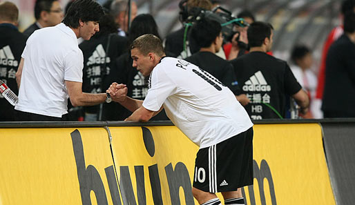Bundestrainer Joachim Löw klatscht nach Spielende mit Torschütze Lukas Podolski ab