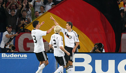 Jubel vor der Deutschland-Flagge: Michael Ballack (l.) und Andreas Beck (M.) feiern Doppeltorschütze Miroslav Klose