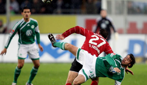 Wolfsburgs Andrea Barzagli (vorne) probiert es akrobatisch gegen Stefan Reisinger