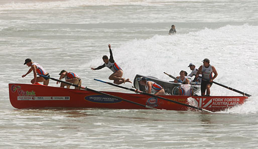 Mann über Bord! Ein Mitglied der Dixon Park SLSC macht den Abflug beim Ocean-Thunder Surf-Boat-Rennen in Sydney, Australien