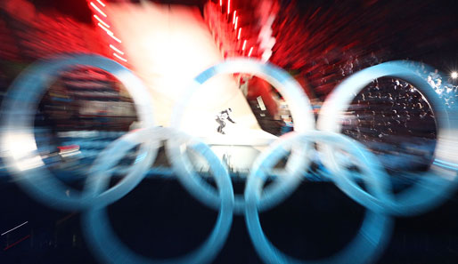 Spektakulärer Auftakt: Ein Snowboarder springt durch die Olympischen Ringe