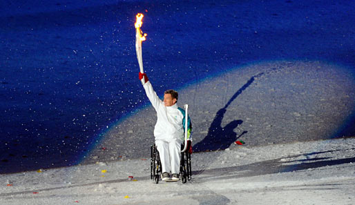Paralympic-Star Rick Hansen trägt die Flamme durchs Rund der Arena