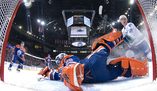 Artistisch stoppt Jeff Deslauriers den Einschussversuch von Mason Raymond im NHL-Spiel zwischen den Edmonton Oilers und den Vancouver Canucks