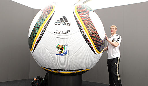 Manuel Neuer neben dem umstrittenen WM-Ball Jabulani. So groß wird die Kugel bei der WM allerdings nicht sein...