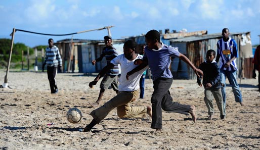 Im Khayelitsha Township in der Nähe von Kapstadt erfreuen sich Jugendliche an einer Partie Fußball.