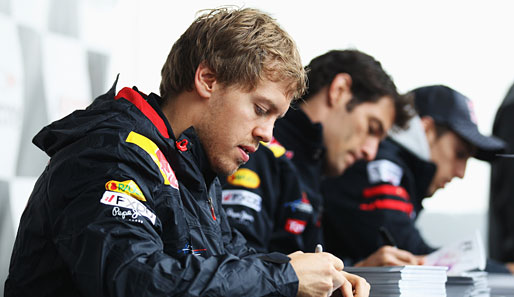 Das Rennen ist erst am Sonntag, gearbeitet wird schon jetzt: Sebastian Vettel (l.) und Mark Webber schreiben in Montreal Autogramme