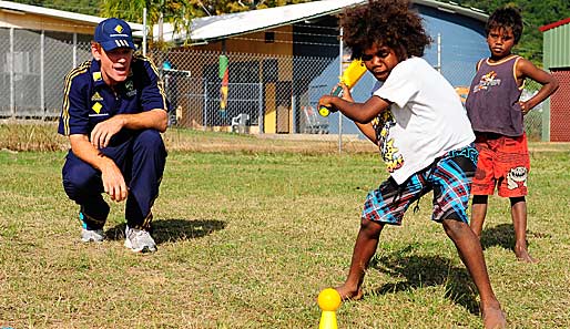 Cricket gehört in Australien zu den beliebtesten Sportarten. Nationalspieler Andrew McDonald führt bei einem Besuch auf Palm Island schon einmal den Nachwuchs heran