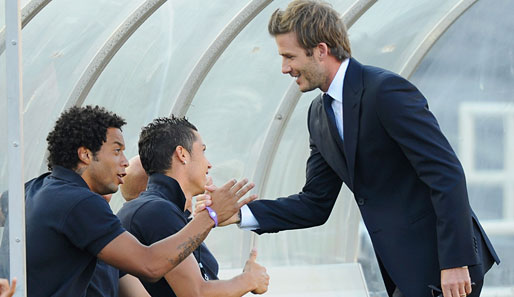 Prominenz auf der Real-Bank. David Beckham (r.), immer noch verletzt, begrüßt seinen ehemaligen Teamkollegen Marcelo. Cristiano Ronaldo (M.) gibt sich im Hintergrund lässig