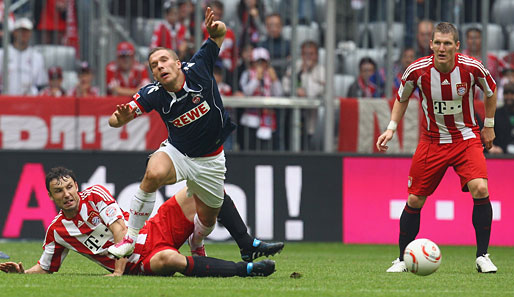 Mit entschlossener Miene setzt Bayern-Kapitän Mark van Bommel gegen Lukas Podolski die Beinschere an.
