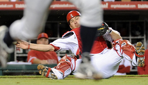 Ichiro Suzuki (v.) macht seinem Nachnamen alle Ehre. Mit Höchstgeschwindigkeit rauscht er über das Baseball-Feld. Jeff Mathis (h.) wird vom Luftzug gepackt und geht zu Boden