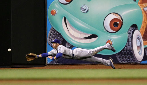 Da freut sich auch die Reklame: Jay Gibbons von den Los Angeles Dodgers hechtet nach einem Ball. Man beachte den Gesichtsausdruck von Auto und Spieler