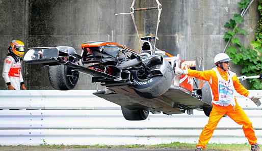 Hilflos musste Hamilton mit ansehen, wie die Streckenposten über seinen McLaren herfielen. Die Radaufhängung war arg ramponiert
