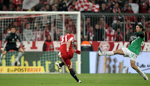 Und hier schickt Bastian Schweinsteiger den Ball zum Siegtreffer auf den Weg - Werder-Kapitän Torsten Frings kommt zu spät