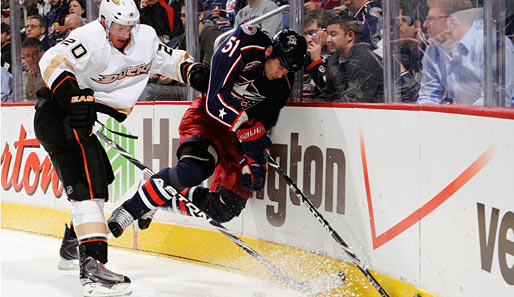 Unsanfte Bekanntschaft mit dem Plexiglas in der NHL: Anaheims Ryan Carter (l.) mit einem Check gegen Columbus' Fedor Tyutin
