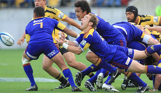 Jimmy Cowan vom neuseeländischen Rugby-Team Highlanders passt den Ball beim Spiel gegen die Hurricanes hingebungsvoll aus der Menschentraube hinter ihm