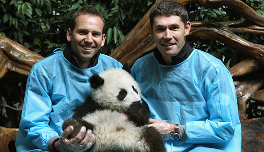 Allerliebst! Die Golfer Sergio Garcia (l.) und Padraig Harrington knuddeln bei den Volvo China Open mit einem überaus drolligen Panda-Baby