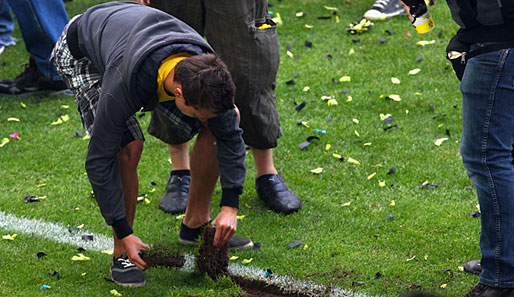 Die BVB-Fans schneiden sich Souvenirs auf dem Dortmunder Rasen