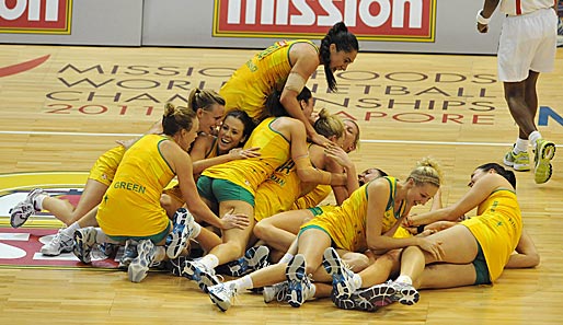 Ein gelbes Mädchen-Knäuel! Die australischen Korbballspielerinnen fallen nach dem Gewinn der Weltmeisterschaft gegen den Erzrivalen Neuseeland übereinander her