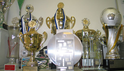 Rechts über seinem Schreibtisch sind die zahlreichen Pokale der Jugendteams ausgestellt. Vielleicht gibt's bald eine Vitrine