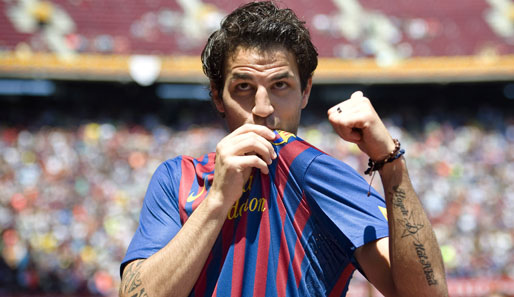 Die Rückkehr von Fabregas! Symbolisch küsst Cesc Fabregas das Emblem vom FC Barcelona bei der offiziellen Vorstellung. Nach langem Tauziehen ist er wieder bei Barca