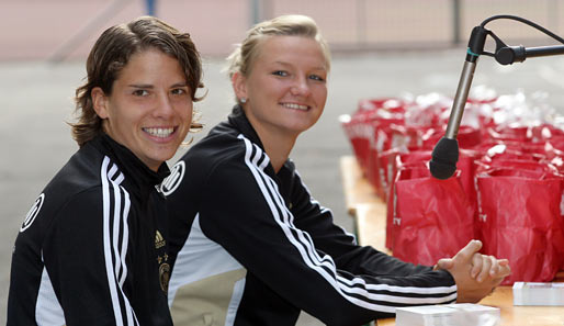 Wie die Honigkuchenpferde: Die Nationalspielerinnen Annike Krahn (l.) und Alexandra Popp besuchen eine Schule in Augsburg