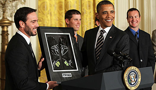 Ein paar Rennhandschuhe für den Präsidenten: NASCAR-Champion Jimmie Johnson (l.) revanchiert sich für die Einladung ins Weiße Haus bei Barack Obama