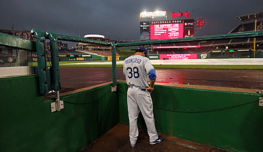 Regenunterbrechung in der MLB-Partie zwischen den L.A. Dodgers und den Washington Nationals. Ramon Troncoso nutzt die Gelegenheit, um gemütlich zu telefonieren
