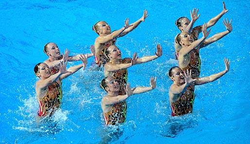 Die US-amerikanischen Synchronschwimmerinnen winken ihren mitgereisten Familien zu - synchron, versteht sich
