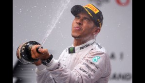 Wilde Dusche. Während Lewis Hamilton spritzt, bekommt er von hinten Rosbergs Champagner in den Nacken