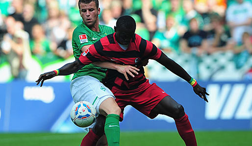 Werder Bremen - SC Freiburg 5:3: Bremens Lukas Schmitz im Nahkampf mit SC-Torjäger Papiss Demba Cisse (r.)