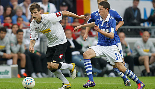 Havard Nordtveit (l.) treibt den Ball durchs Mittelfeld, Schalkes Julian Draxler gibt Geleitschutz
