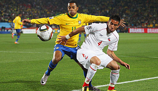 Chile-Verteidiger Mauricio Isla schirmt den Ball gegen Brasilien-Angreifer Robinho ab (l.)