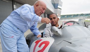 Sir Stirling Moss erklärt Lewis Hamilton das alte Fahrzeug
