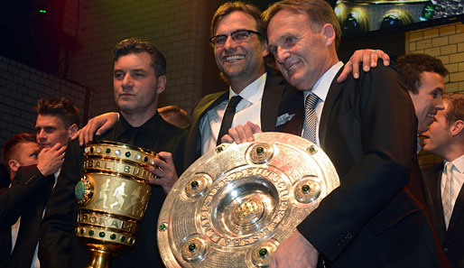 Jürgen Klopp (M.) präsentiert stolz die Trophäen dieser Saison