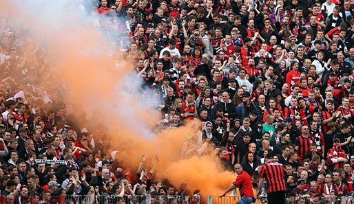 Fans der Frankfurter Eintracht beim Zünden eines Bengalos im Fan-Block