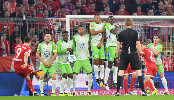 Robert Lewandowski (l.) schießt einen direkten Freistoß gegen den VfL Wolfsburg