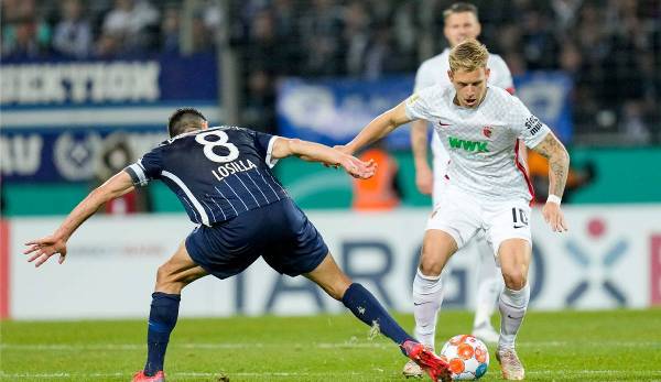 Augsburg's Arne Maier tries to get past Bochum captain Anthony Losilla.