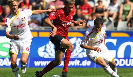 Freiburg - Leverkusen 0:5: Die Leverkusener Simon Rolfes (l.) und Tranquilo Barnetta (r.) attackieren den Freiburger Julian Schuster