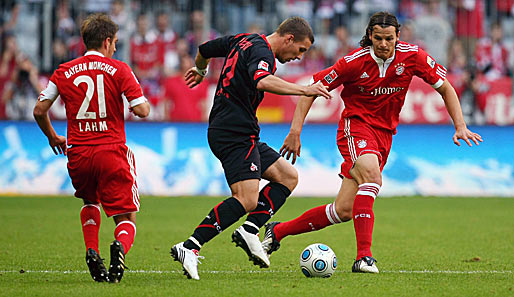 Podolski (M.) im Duell mit seinen ehemaligen Teamkollegen van Buyten (r.) und Lahm