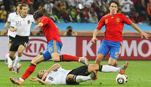 Mesut Özil am Boden: Die spanische Defensive um Carles Puyol hatte die DBF-Elf stets sicher im Griff