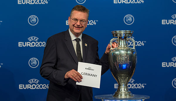 Reinhard Grindel posiert vor dem EM-Pokal
