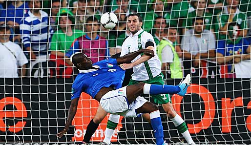 Mario Balotelli (l.) trifft artistisch gegen Irland, Verteidiger O'Shea kann nur zuschauen