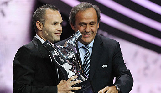 Andres Iniesta bekommt von UEFA-Präsident Michel Platini die Trophäe überreicht