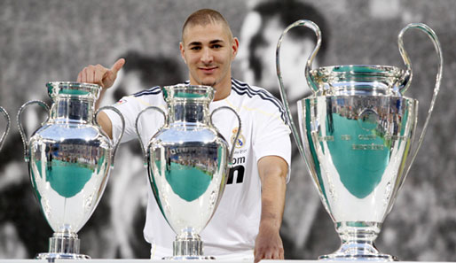 Karim Benzema posiert vor den Europapokalen der Königlichen. Das Lachen wirkt noch gequält