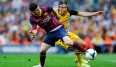 Lionel Messi (l.) verteidigt den Ball gegen Felipe Luis