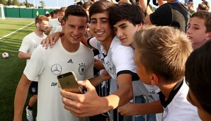 Julian Draxler posiert mit jungen russischen Fans nach der ersten Trainingseinheit des DFBs