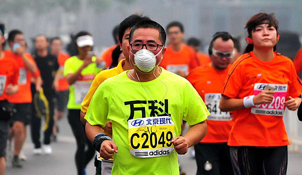 Zahlreiche Läufern versuchen sich mit einer Maske vor dem Smog zu schützen