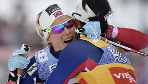 Therese Johaug (l.) wird nach der Zieldurchfahrt von Landsfrau Marit Björgen beglückwünscht