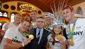 Die Medaillengewinner feiern mit Thomas de Maiziere